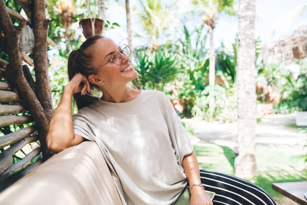 Pretty woman sitting outdoors - routine eye exam in Costa Mesa, CA Pretty woman sitting outdoors - routine eye exam in Costa Mesa, CA