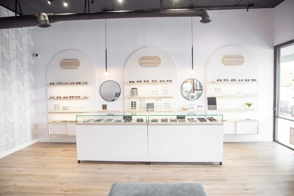 Optical frame display area at One EyeCare in Costa Mesa, featuring curated eyewear collections on backlit shelves inside the modern, boutique-style office
